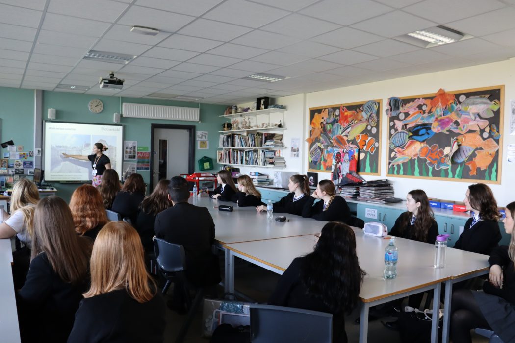 Students in a classroom within their school watch a Courtauld Learning Team educator present on a projector screen,