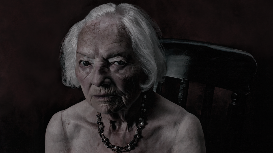 Contemporary portrait photograph of a woman from Glasgow, shown from the shoulders up against a neutral background, with direct gaze and natural lighting emphasizing facial features and expression, part of a series exploring identity and perception.
