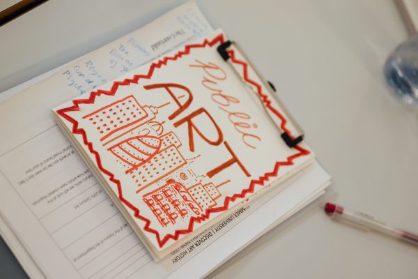 A photograph of a paper booklet, created by a summer university student. The title on the front says 'public art' with some drawings of tall buildings.