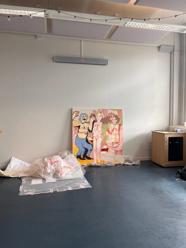 A work, unpacked, packaging beside, propped against a wall