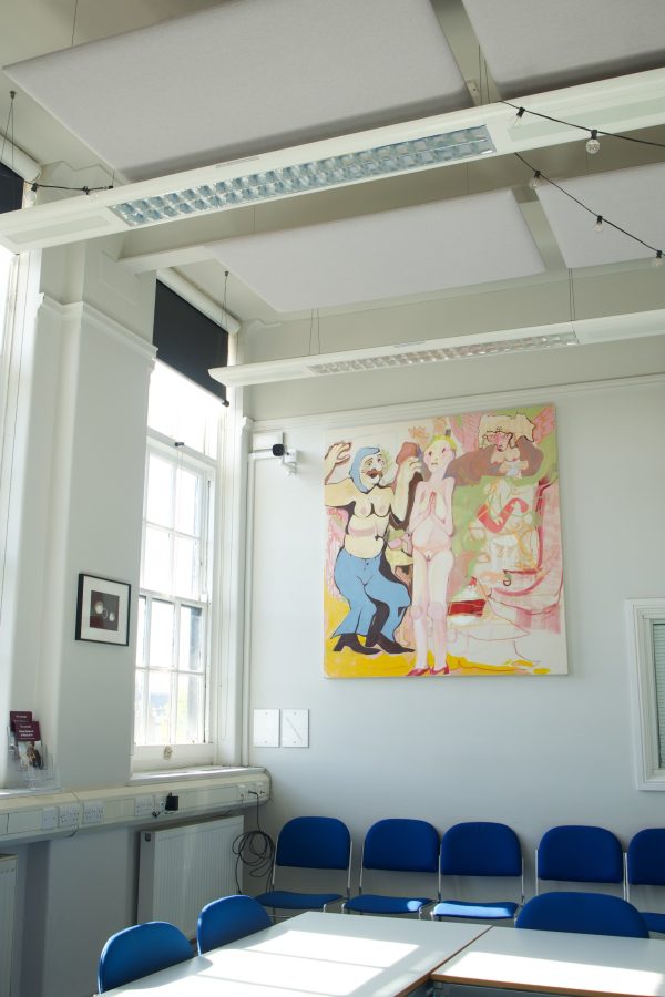 A painting hanging on a wall by a window