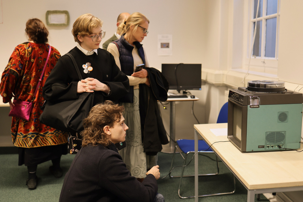 Visitors at the East Wing Biennial view an artwork