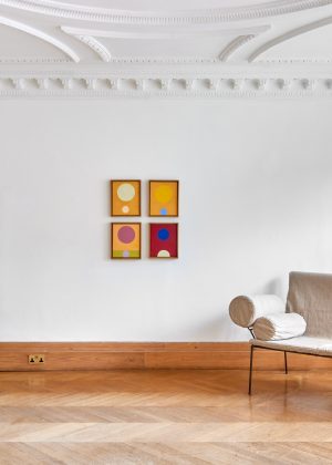 An image of the The Nicoletta Fiorucci Foundation exhibition. Four artworks on a white wall with a chair in the foreground.
