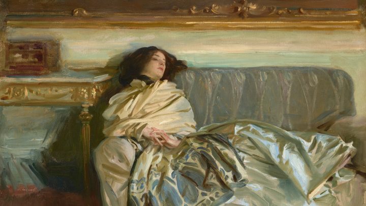 A woman lies on a sofa