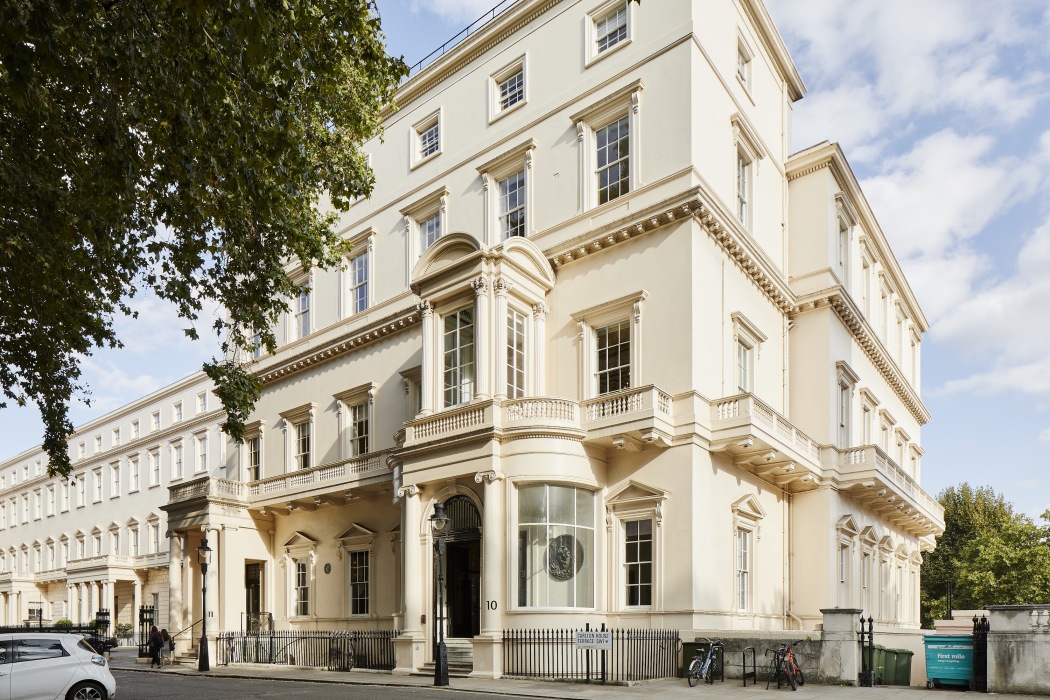 A white townhouse on a street in London, a tree beside it.