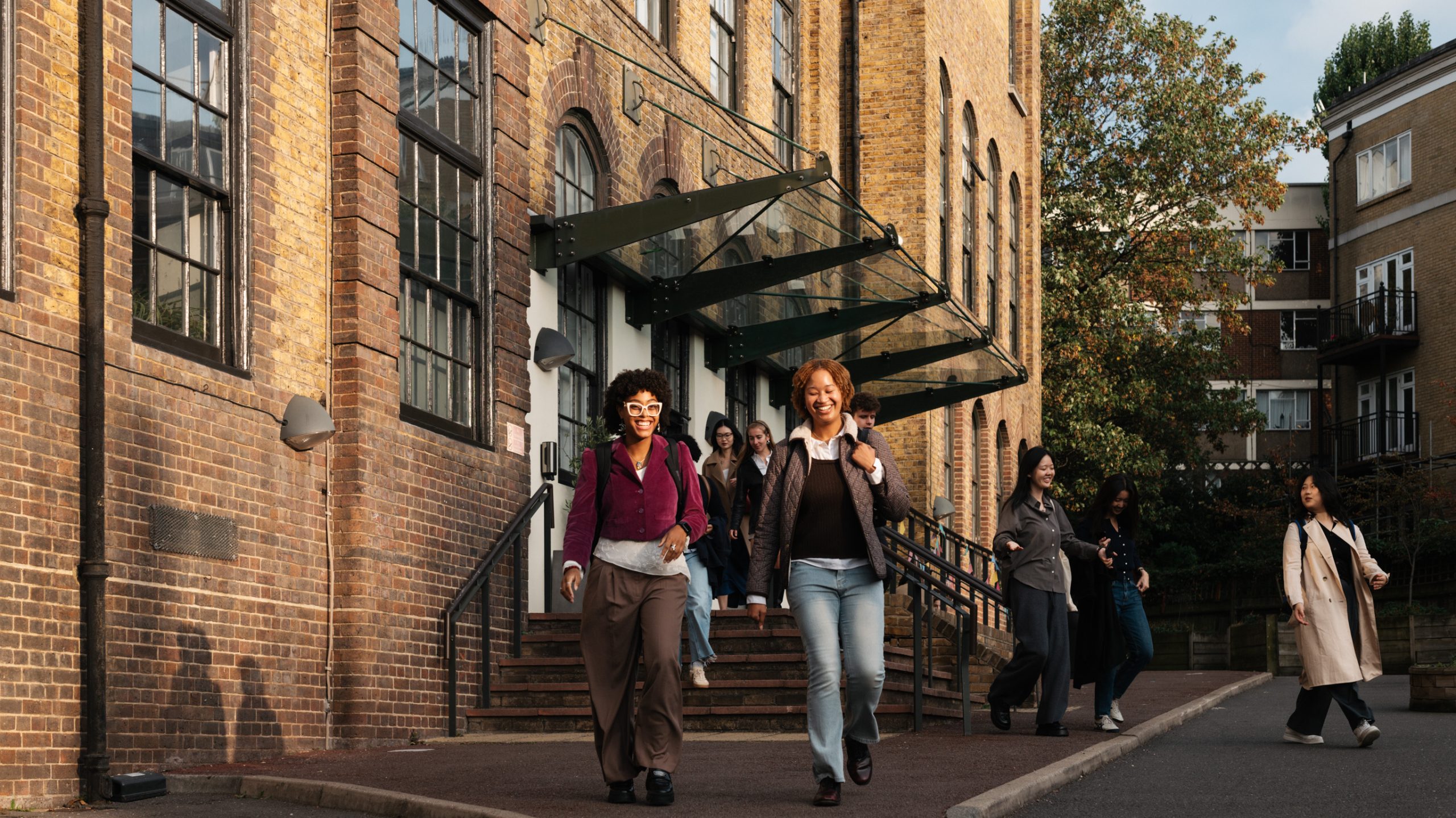 A number of smiling students exit the Courtauld Vernon Square campus.