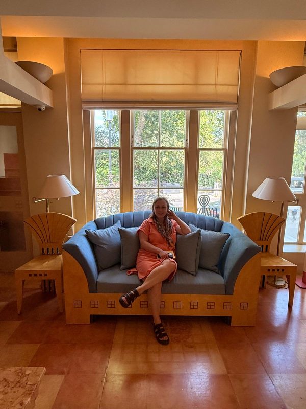 a single female sits contemplatively on a sofa in The Cosmic House