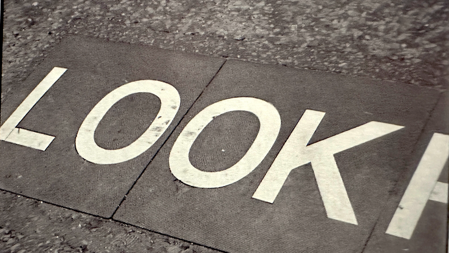 the word Look written on a pavement.