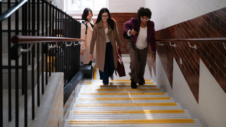 Three students walk up stairs at Vernon Square campus.