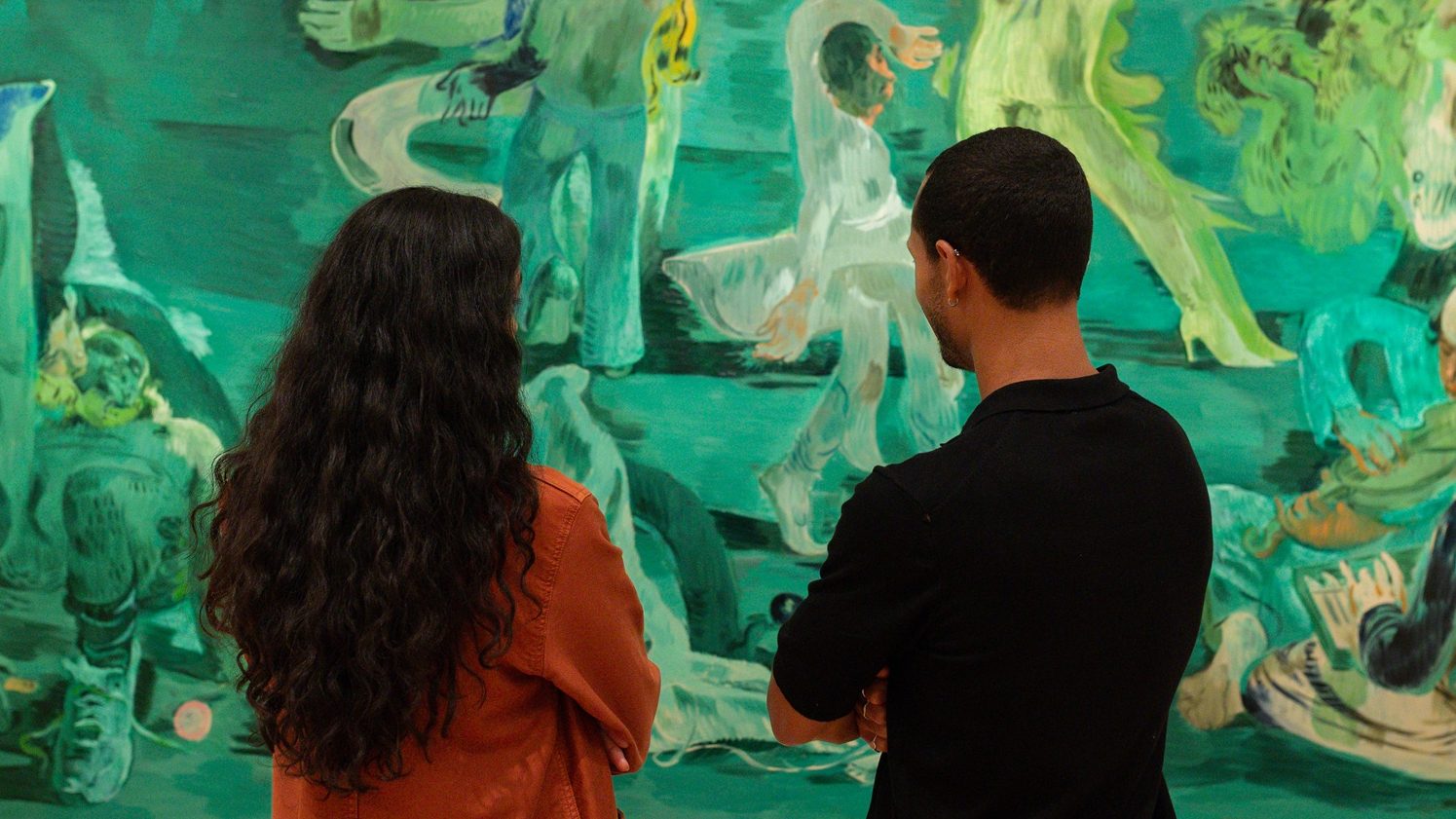 Two people stand in front of Salman Toor's large scale painting, Ghost Ball