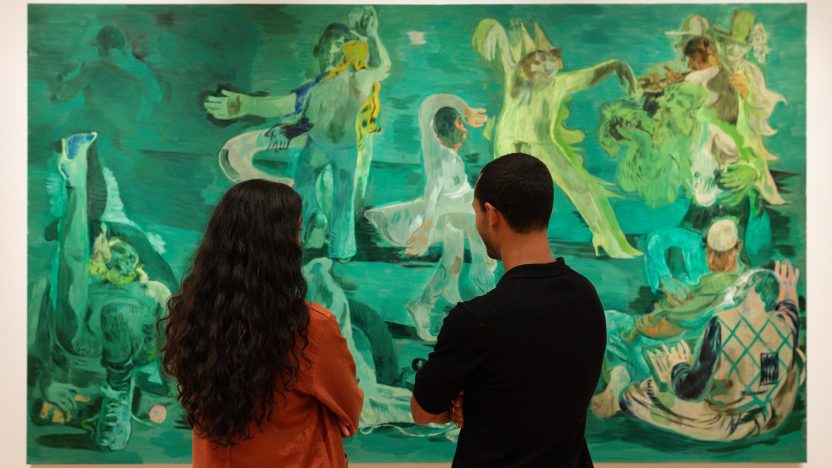 Two people stand in front of Salman Toor's large scale painting, Ghost Ball